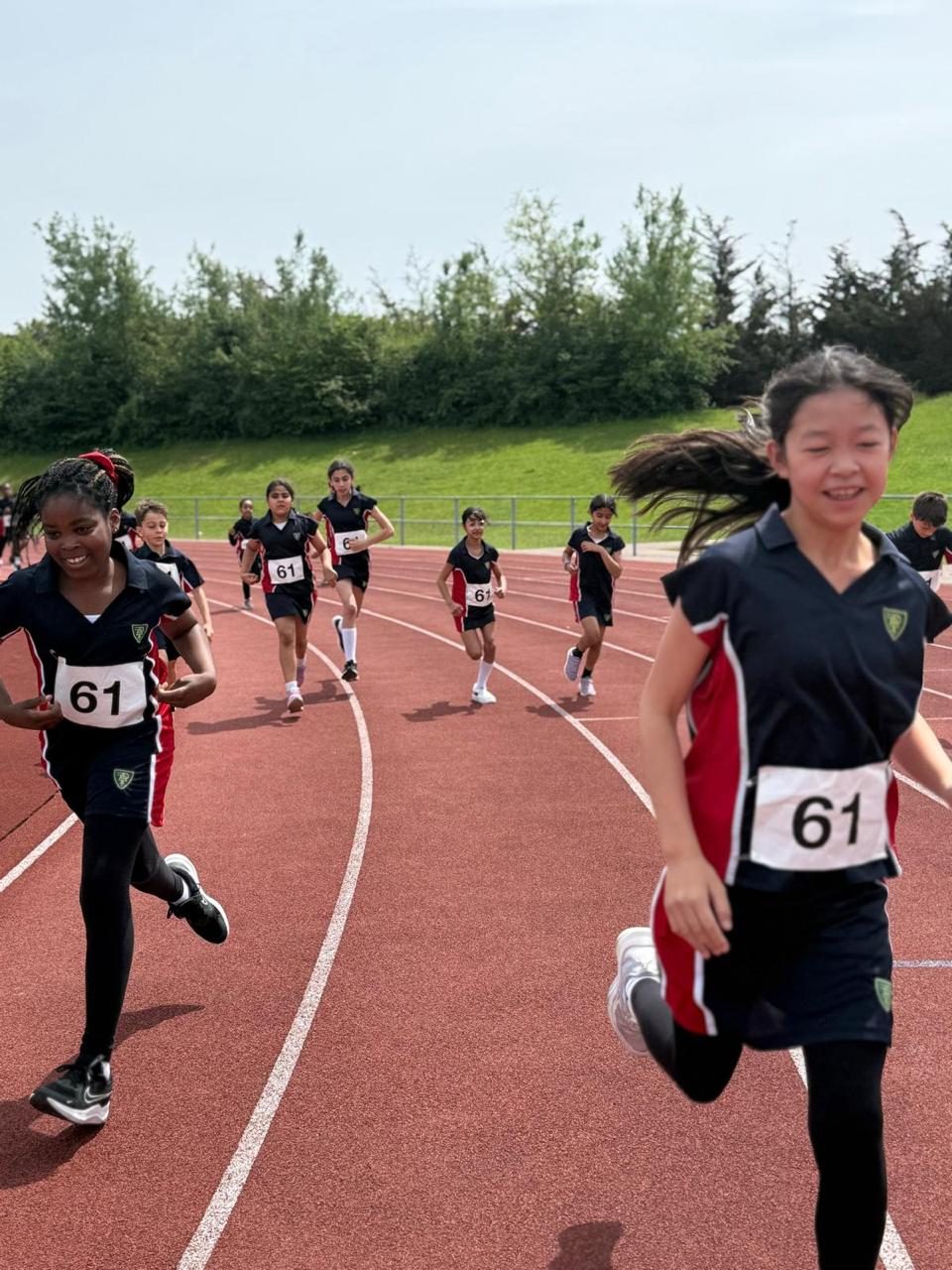 Pupils race neck and neck along the track on sports day.