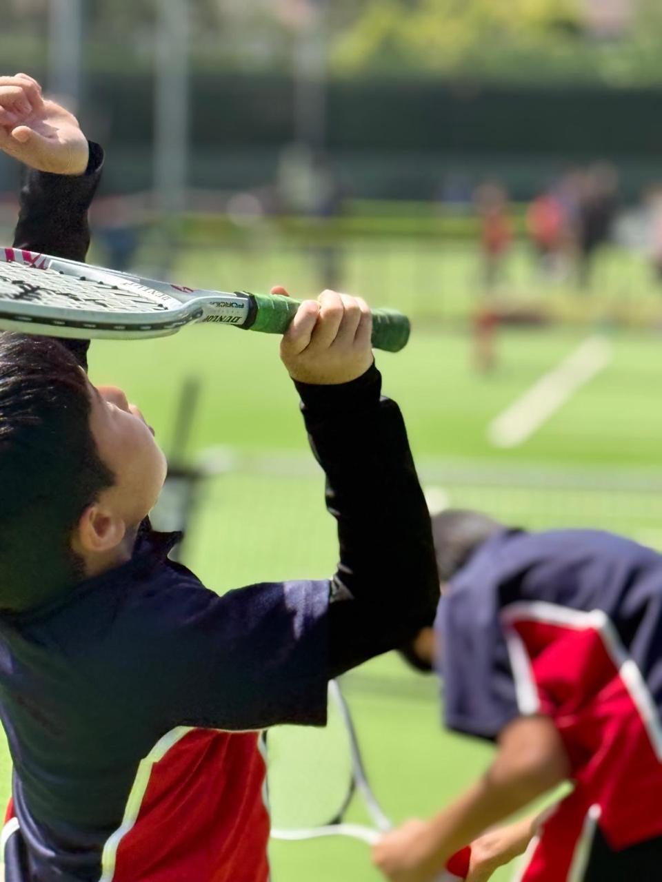 Pupils take part in a tennis coaching session.