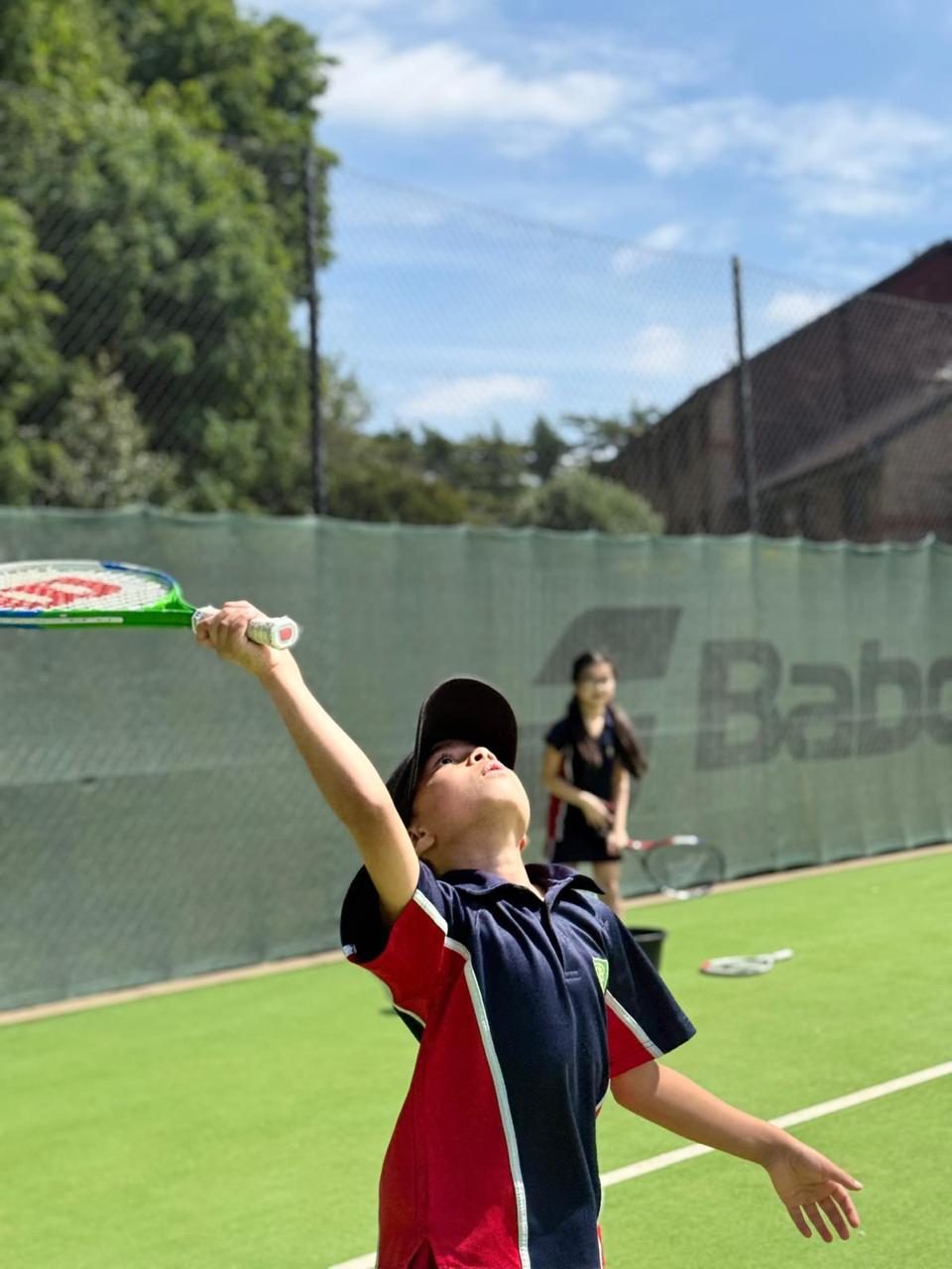 A pupil prepares to serve during a tennis lesson.