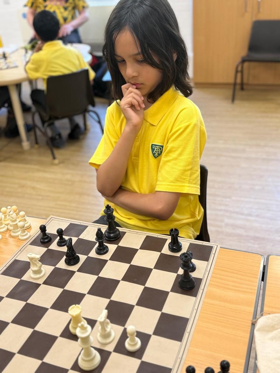 A pupil pauses to think through his next move at chess.