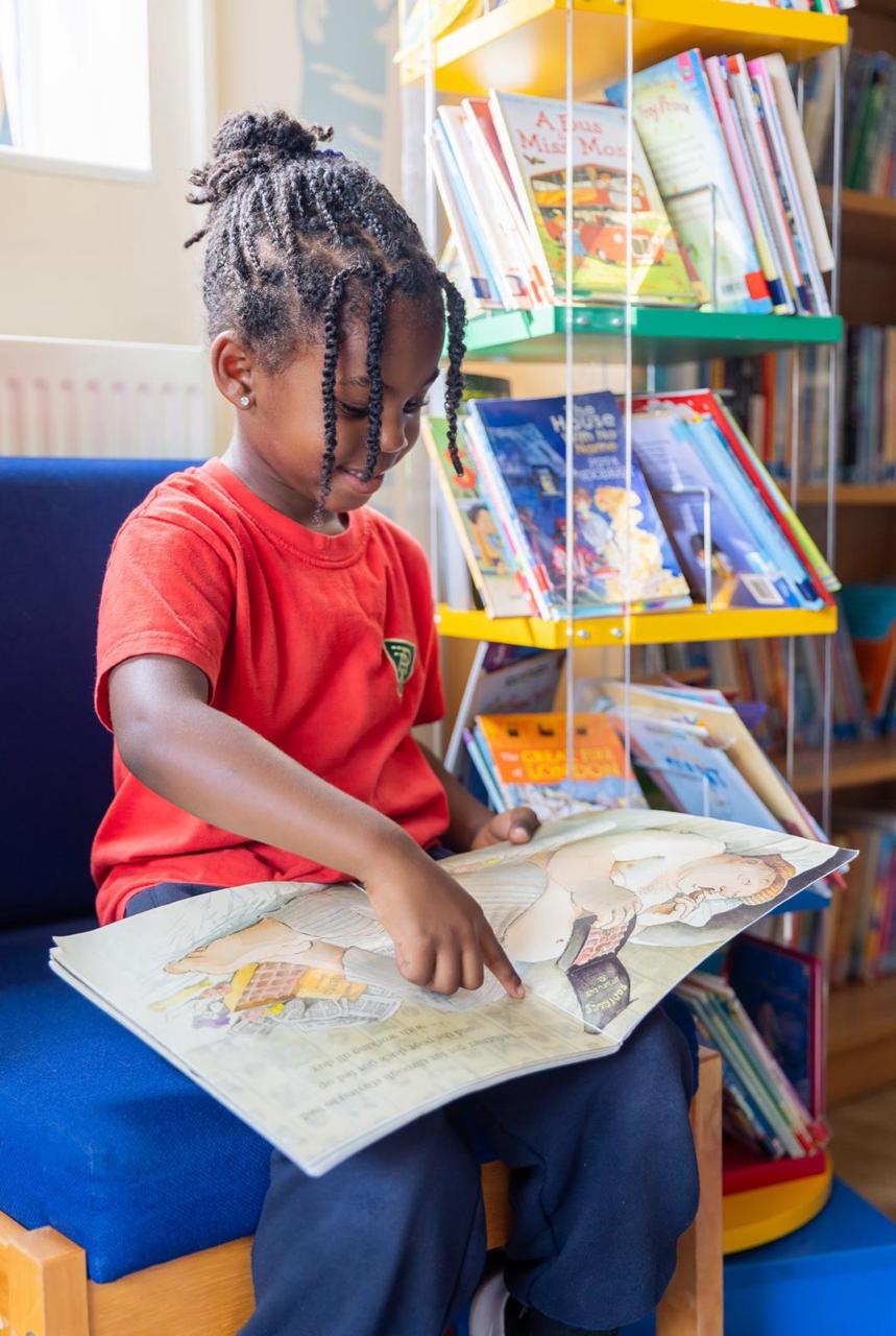 A pupil enjoying a book in the school library at Vita et Pax Preparatory School