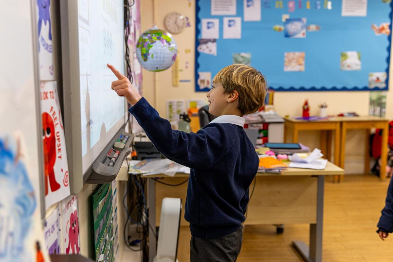 Prep school pupil answering at the interactive whiteboard at Vita et Pax Preparatory School, Southgate