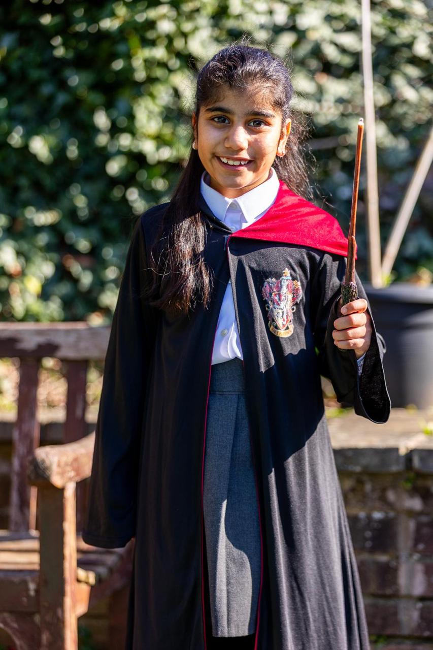 A smiling pupil in a wizard robe celebrating World Book Day at Vita et Pax