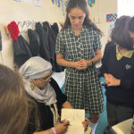 woman signing a book in class